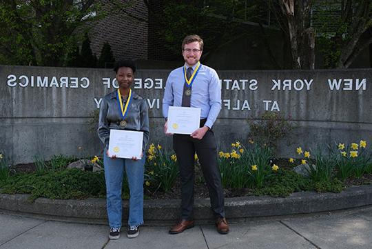 two people, man and woman, with award certificates